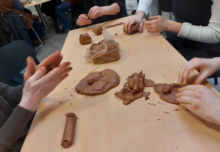 personne en train de faire de la terre glaise lors d'un atelier de groupe d'art-thérapie