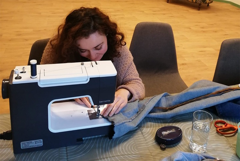 femme en train de faire de la couture avec une machine à coudre lors d'un cours de couture